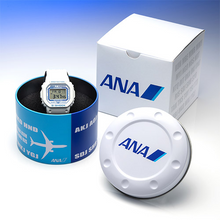Casio G‑SHOCK x ANA DW‑5600 limited edition aviation watch with white dial, blue ANA logo, resin strap featuring airport codes, airplane LED backlight, engraved caseback, exclusive ANA packaging — available at WatchOutz.com  with secure worldwide shipping