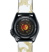 Seiko X Bruce Lee 5 Sports 55th Anniversary SKX Sense Style Limited Edition Watch, model SRPK39 SBSA239 SRPK39k1. Features black case and leather strap inspired by Bruce Lee's Kung Fu uniform, golden dragon motifs, additional yellow and black nylon strap, and dragon motif dial. Includes commemorative box and postcard. Limited to 5,000 pieces, with "Jeet Kune Do" core symbol on case back. Available now at Watchoutz.com: fast shipping, exceptional customer service, seamless shopping experience, and community