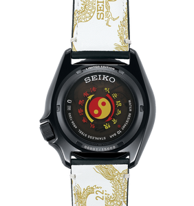 Seiko X Bruce Lee 5 Sports 55th Anniversary SKX Sense Style Limited Edition Watch, model SRPK39 SBSA239 SRPK39k1. Features black case and leather strap inspired by Bruce Lee's Kung Fu uniform, golden dragon motifs, additional yellow and black nylon strap, and dragon motif dial. Includes commemorative box and postcard. Limited to 5,000 pieces, with "Jeet Kune Do" core symbol on case back. Available now at Watchoutz.com: fast shipping, exceptional customer service, seamless shopping experience, and community