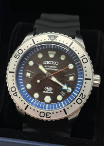 Seiko Prospex X Subaru Collaboration Automatic 200M Diver Limited Edition JDM SZEL010. Limited edition of 300 pieces. Features 200m water resistance, high-quality silicon band, JIS/ISO compliance for magnetic/shock resistance, automatic movement with 41-hour power reserve. Inspired by SUBARU’s design with blue dial, hexagon pattern, and Hawk Eye elements. Available on Watchoutz.com, best online watch shop, fast intrernational shipping, genuine products only, satisfy customers from worldwide
